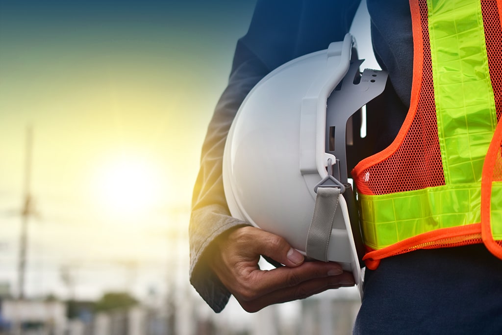 Construction worker holding their hard hat by their side